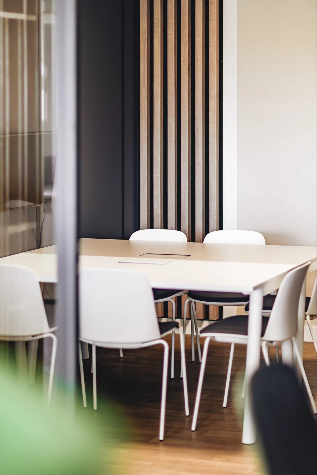 Petite salle, chaises blanches autour de la table